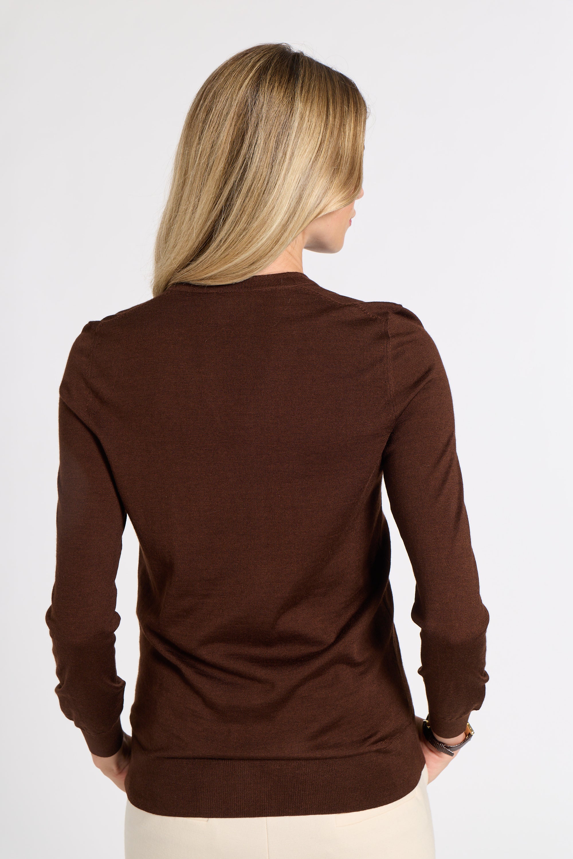 Woman modeling a brown cashmere cardigan in a studio