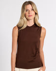 Woman wearing a brown cashmere shell on a white background