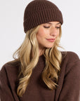 Woman modeling a brown cashmere beanie in a studio