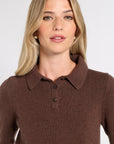 Woman modeling a collared cashmere sweater on a white background