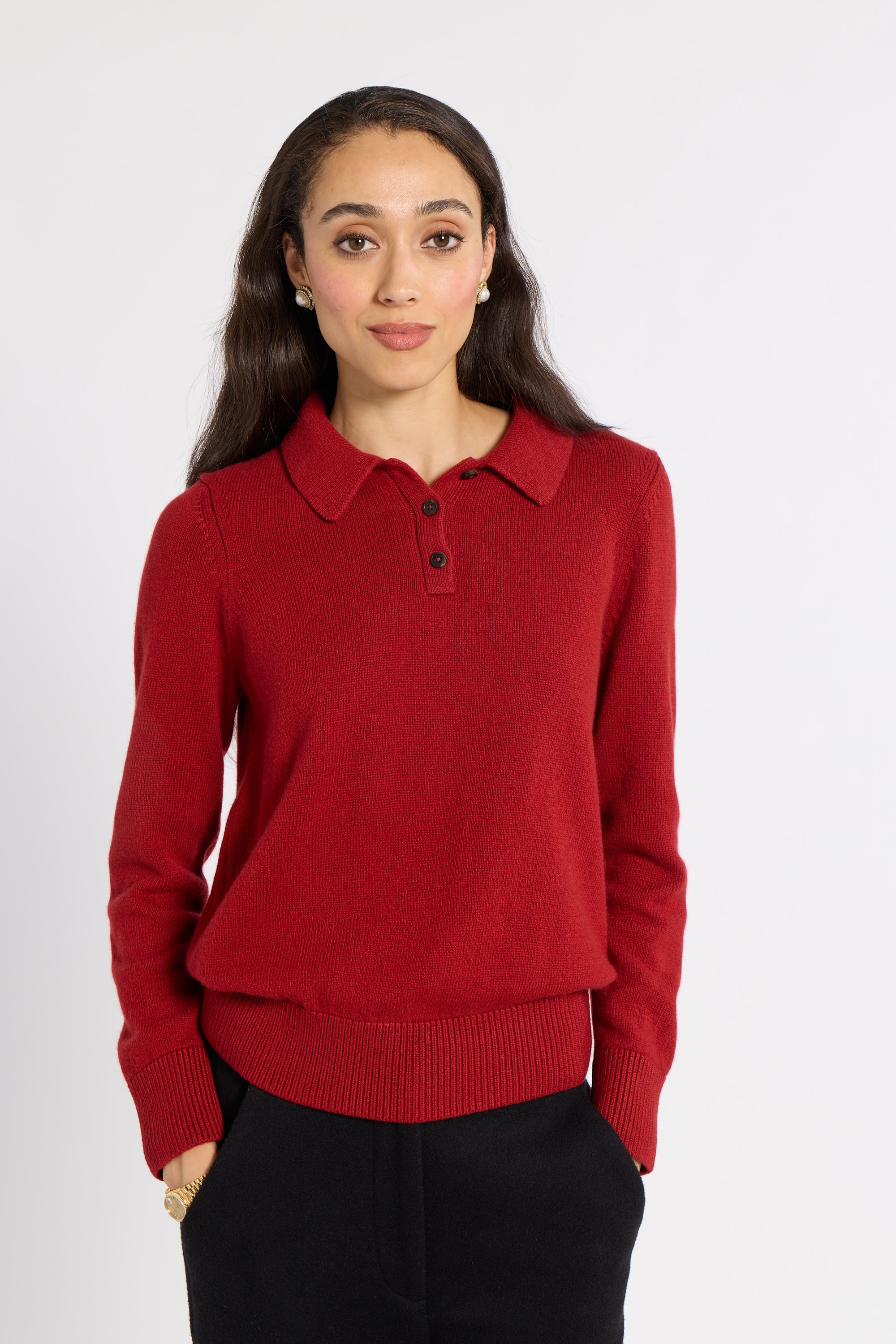 Woman modeling a red cashmere polo in a studio
