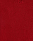 Close-up of a red knit polo shirt showing the textured fabric and a partial buttoned collar.