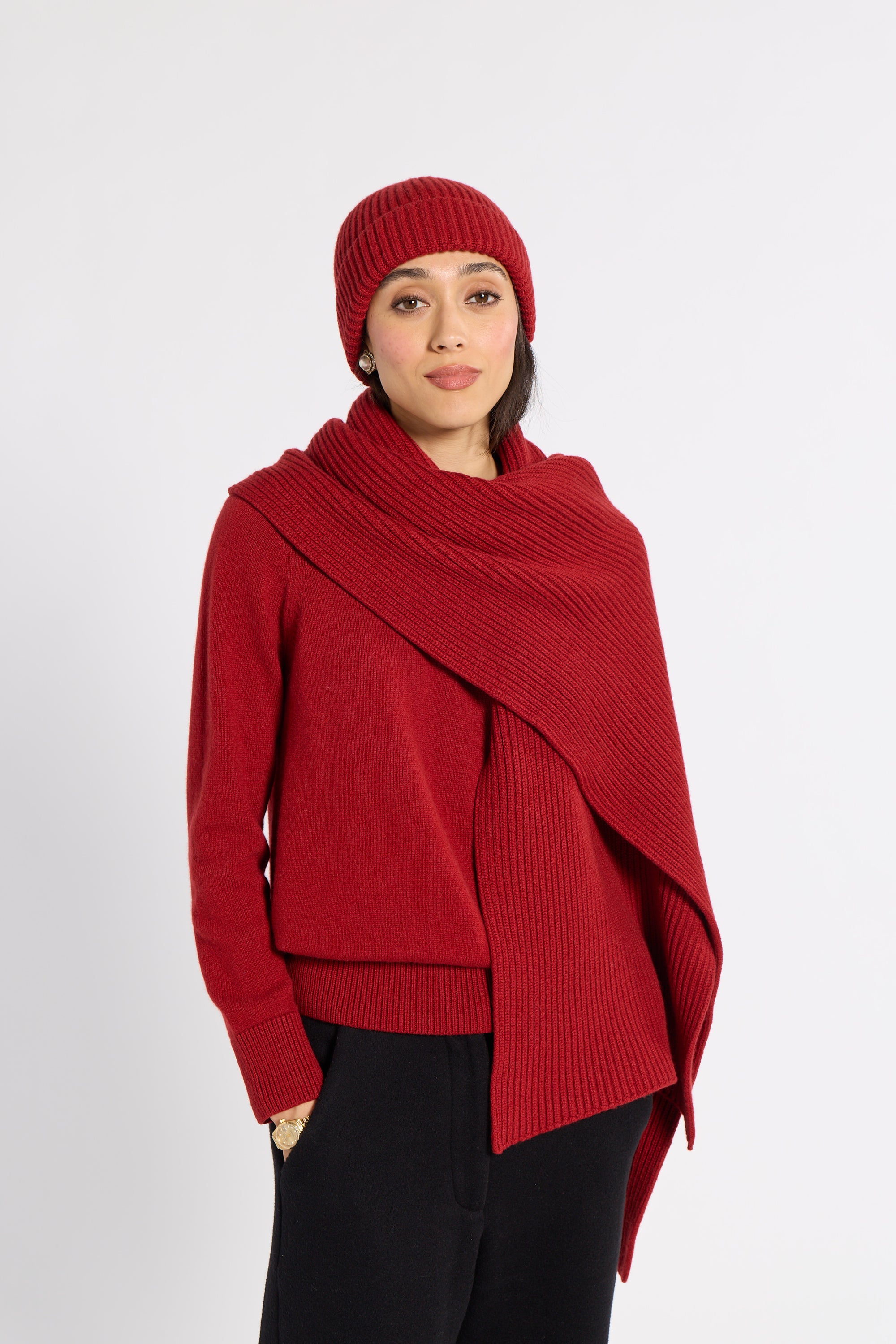 Woman modeling a red cashmere scarf in a studio