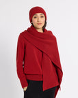 Woman modeling a red cashmere scarf in a studio