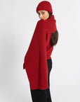 Woman modeling a red cashmere scarf and beanie in a studio