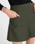 Woman wearing hunter green shorts in a studio
