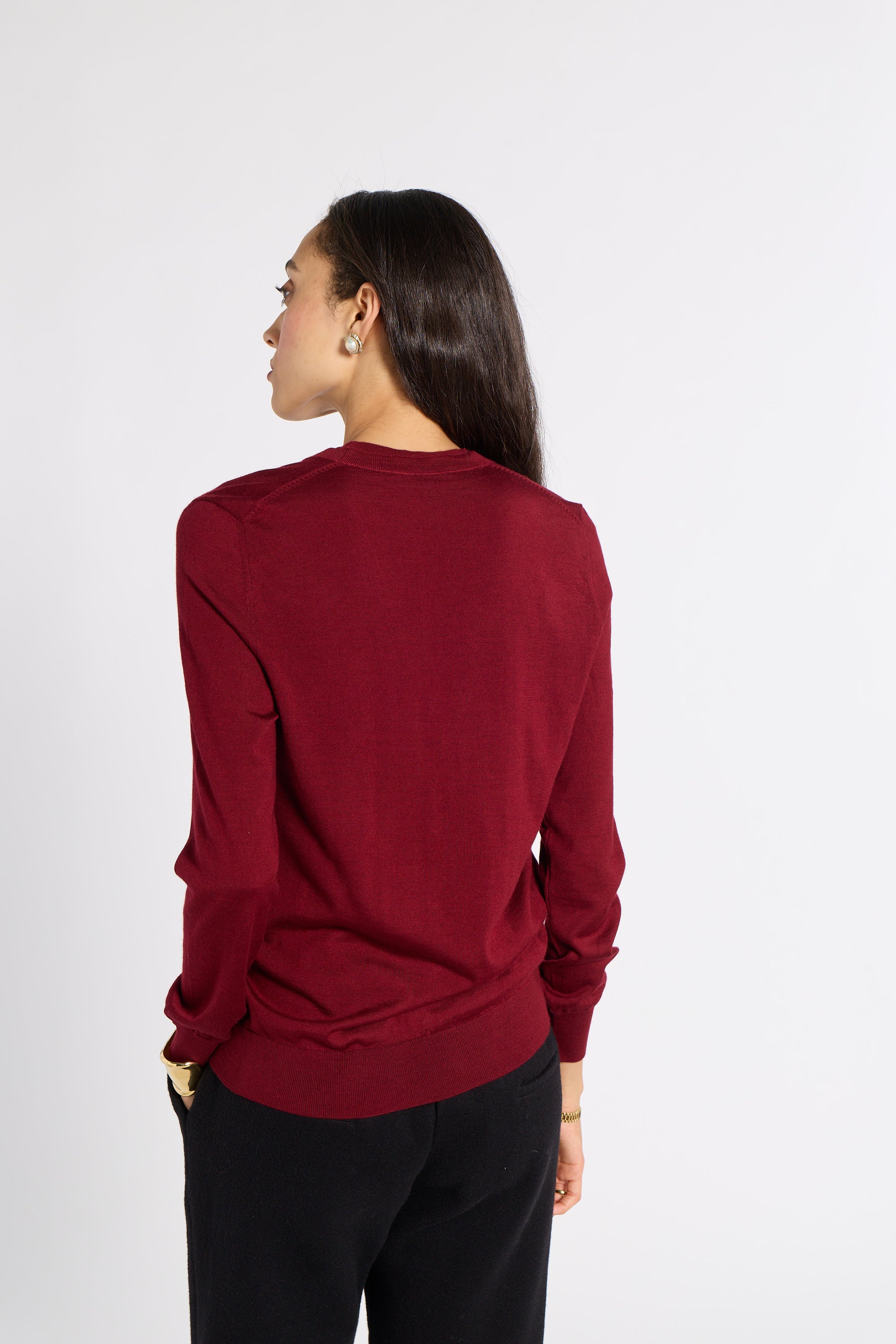 Woman modeling a red tissue cardigan in a studio