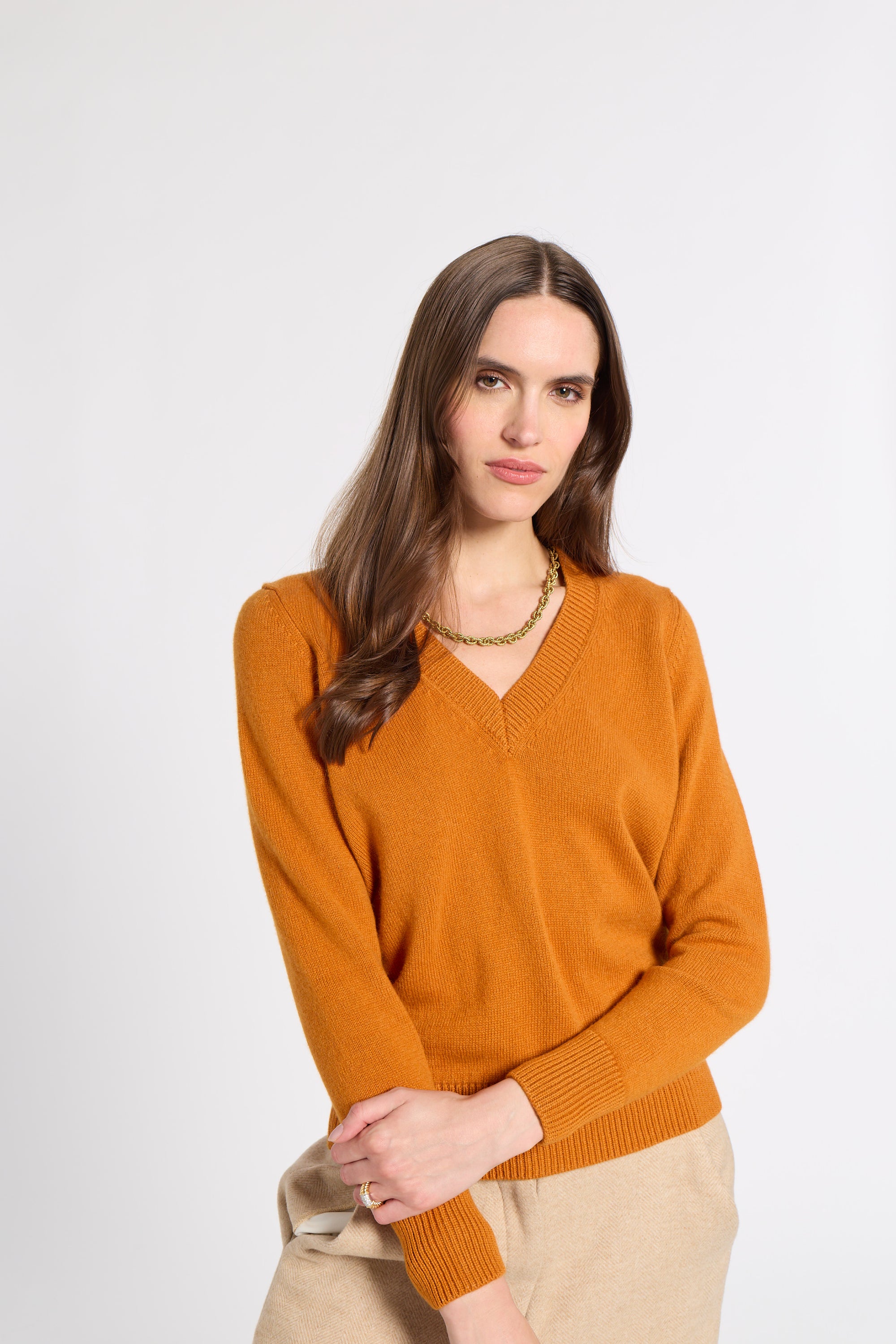 Woman modeling an orange v-neck cashmere sweater