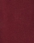 Close-up of a ribbed knit sweater in a deep burgundy red color, showing the detailed texture of the yarn.