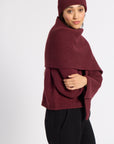 Woman wrapped in a burgundy cashmere scarf and beanie