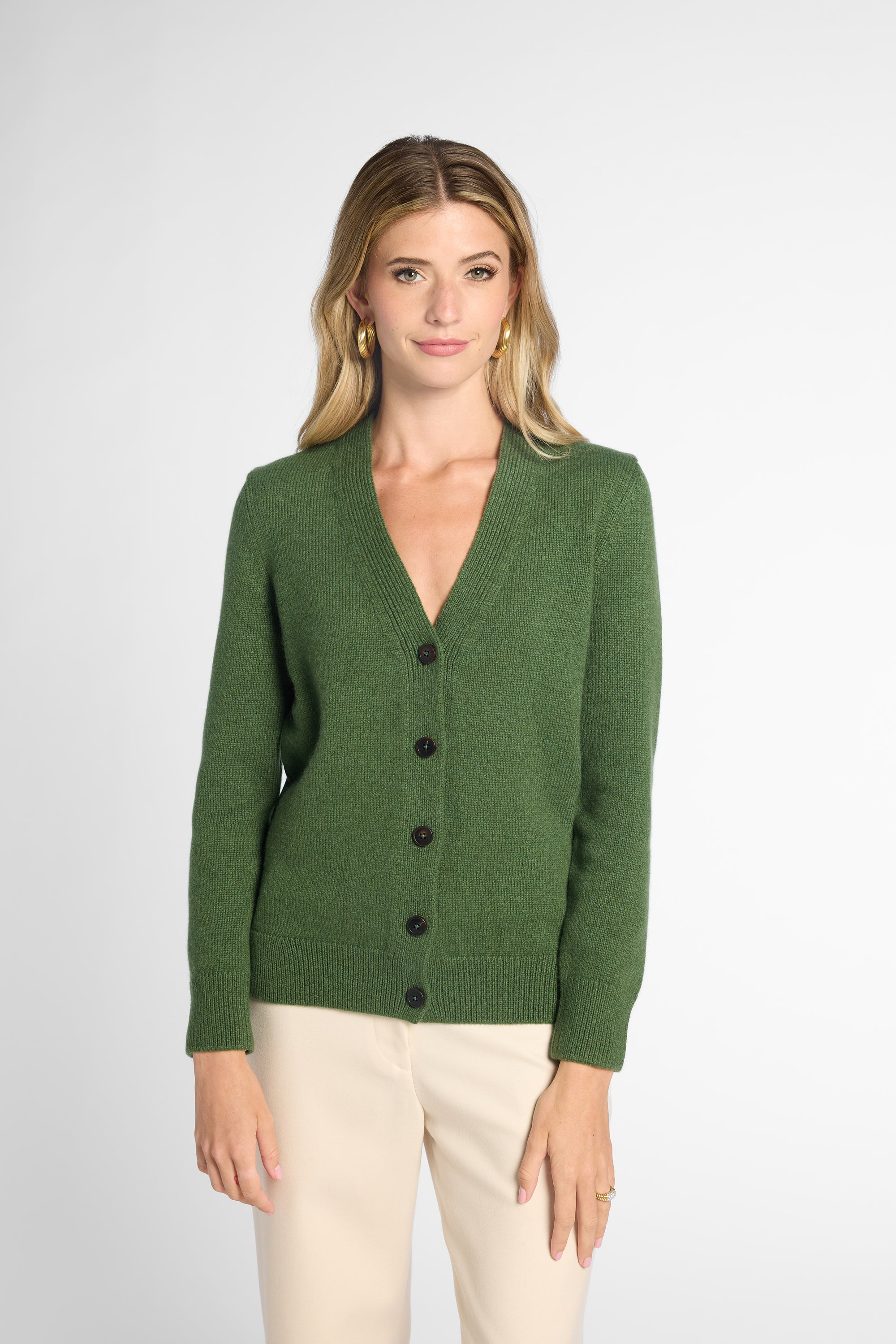 Front view: Woman wearing Forest Green v-neck button up cardigan in front of white background. 