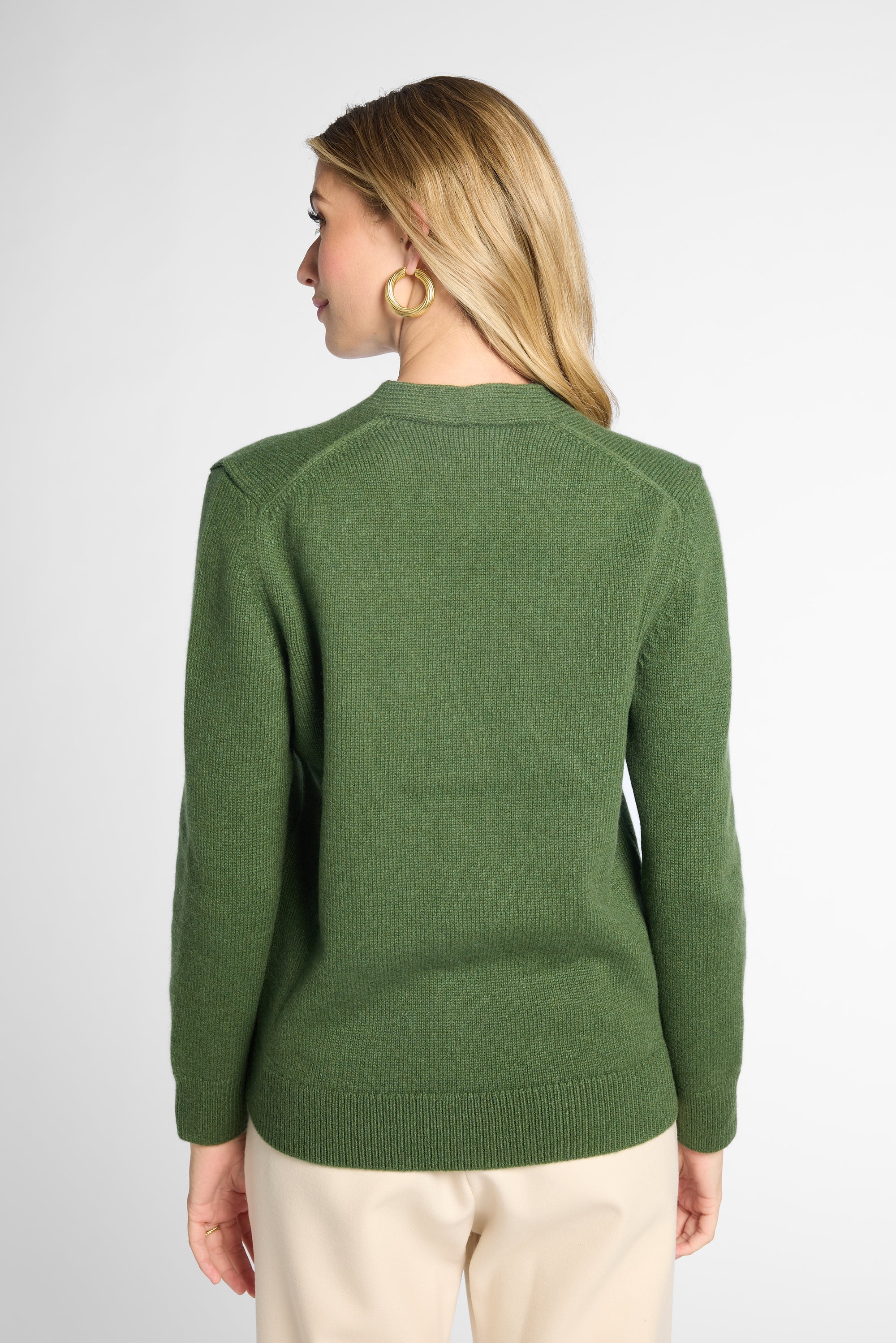 Back view: Woman wearing Forest Green v-neck button up cardigan in front of white background. 