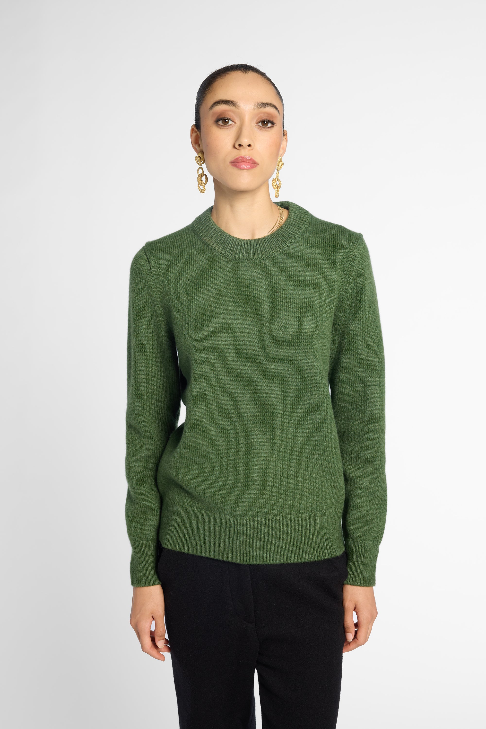 Front view: Woman wearing Forest Green crewneck sweater in front of white background. 