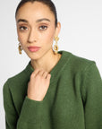 Close view: Woman wearing Forest Green crewneck sweater in front of white background. 