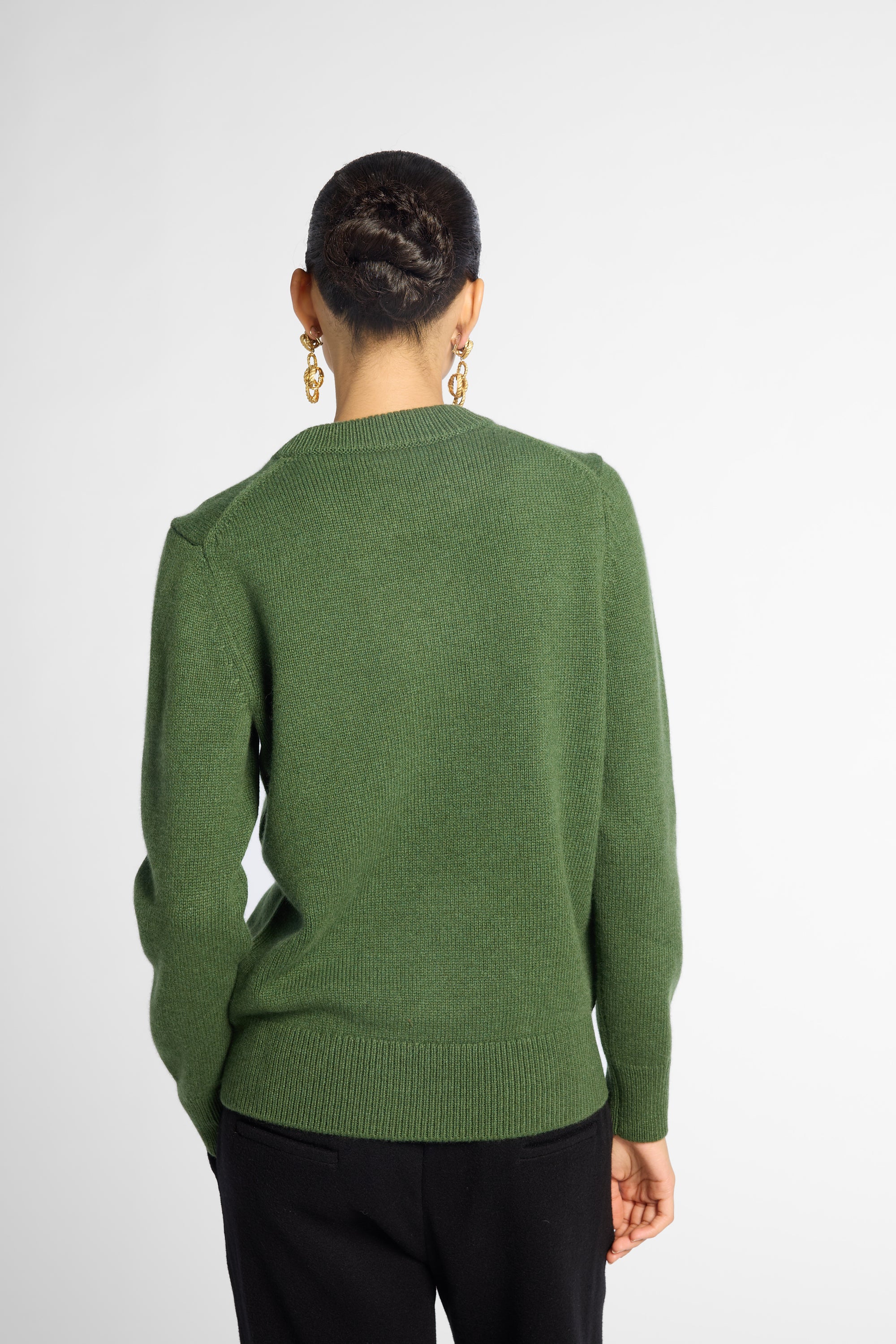 Back view: Woman wearing Forest Green crewneck sweater in front of white background. 