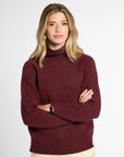 Front view of woman in wine-colored boyfriend turtleneck sweater in front of a white background.