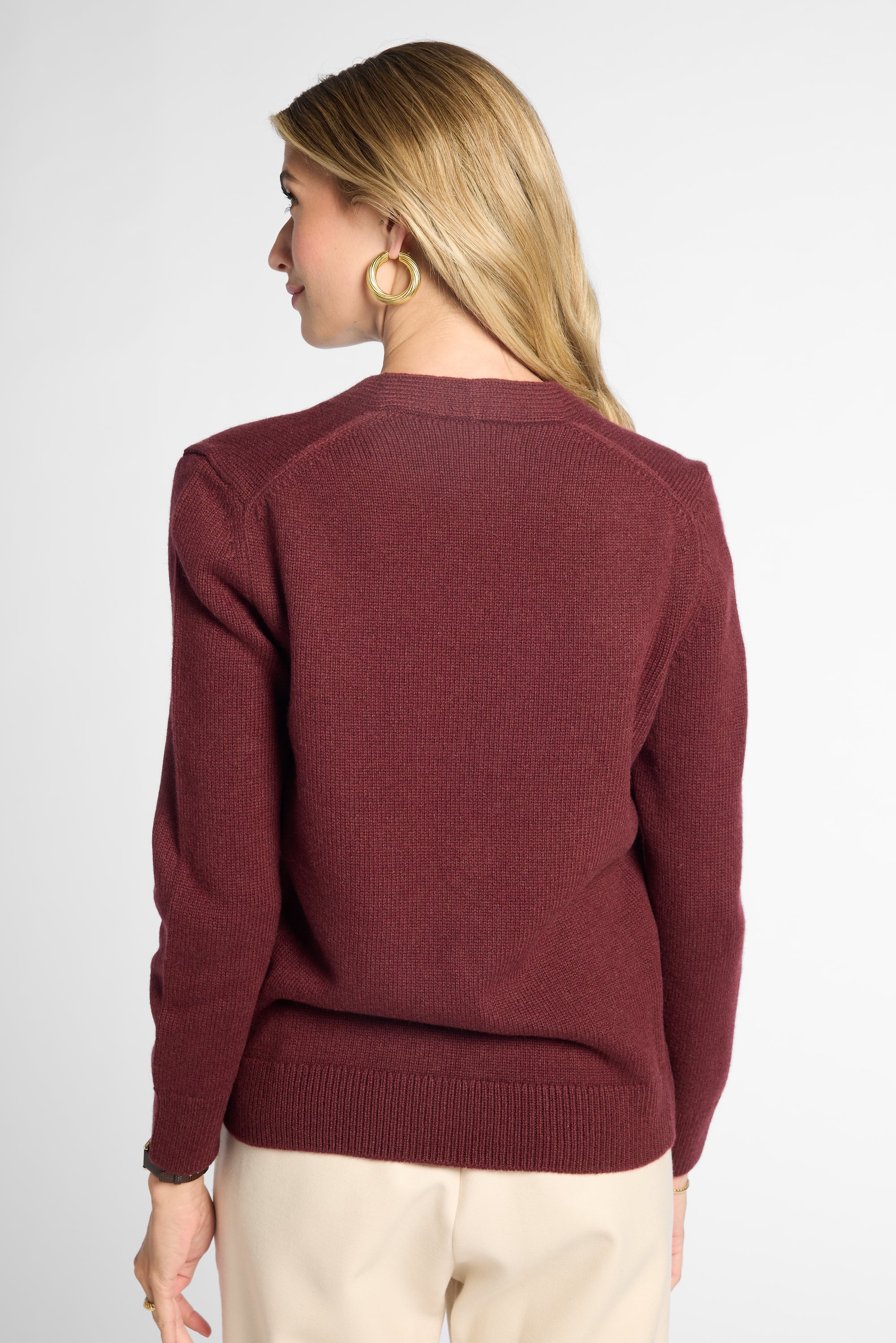 back view of woman in Wine button-up cardigan in front of neutral background.
