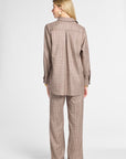 A woman shown from the back wearing a matching brown and beige plaid blazer and wide-leg trousers set, photographed against a light gray studio background.
