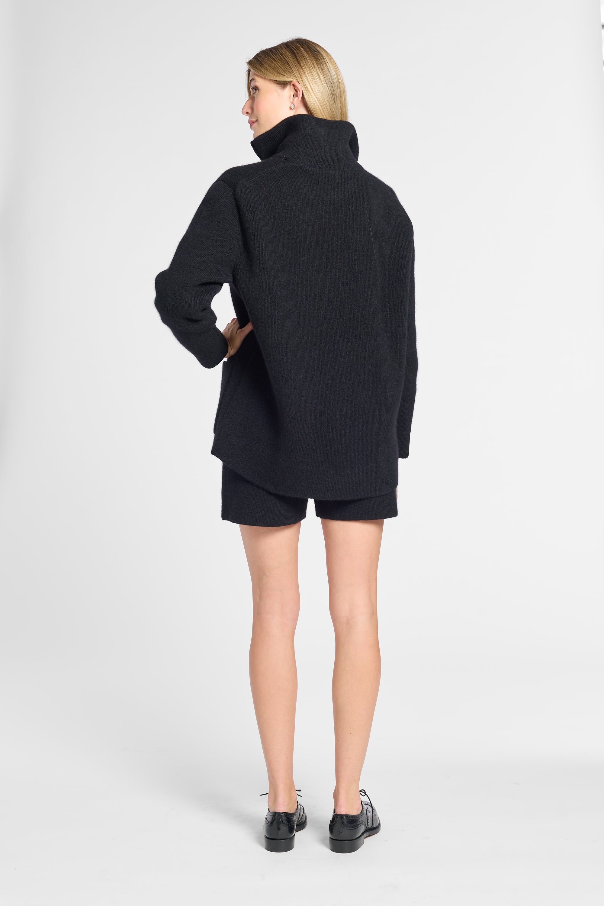 Woman modeling a black cashmere quarter zip in a studio