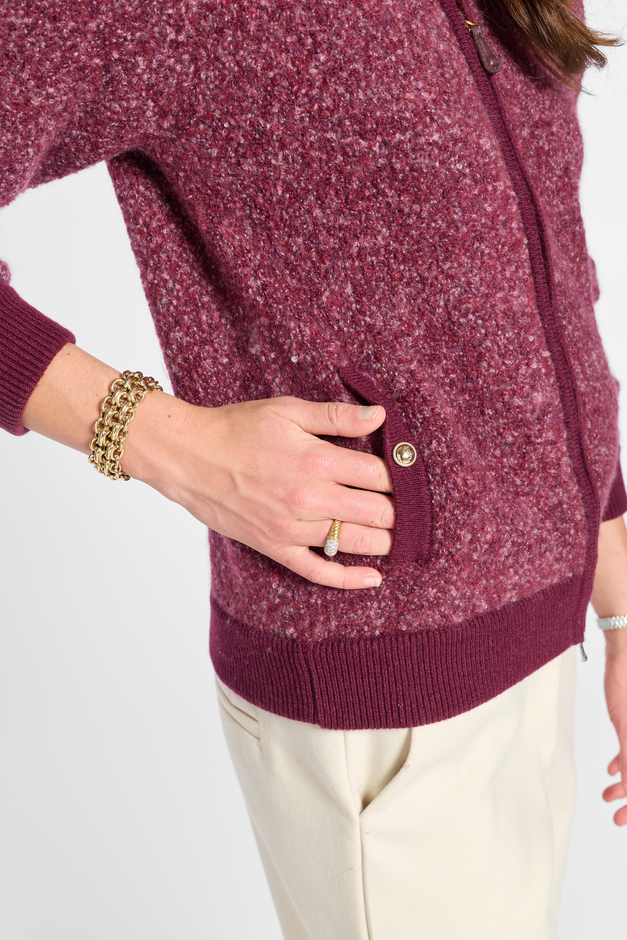 Button and pocket detail of a purple bomber jacket and white pants