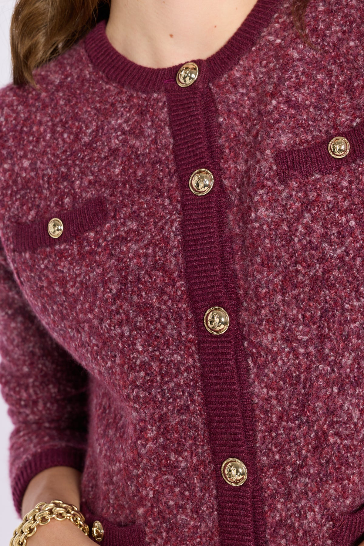 Close up of button detailing on a purple sweater 