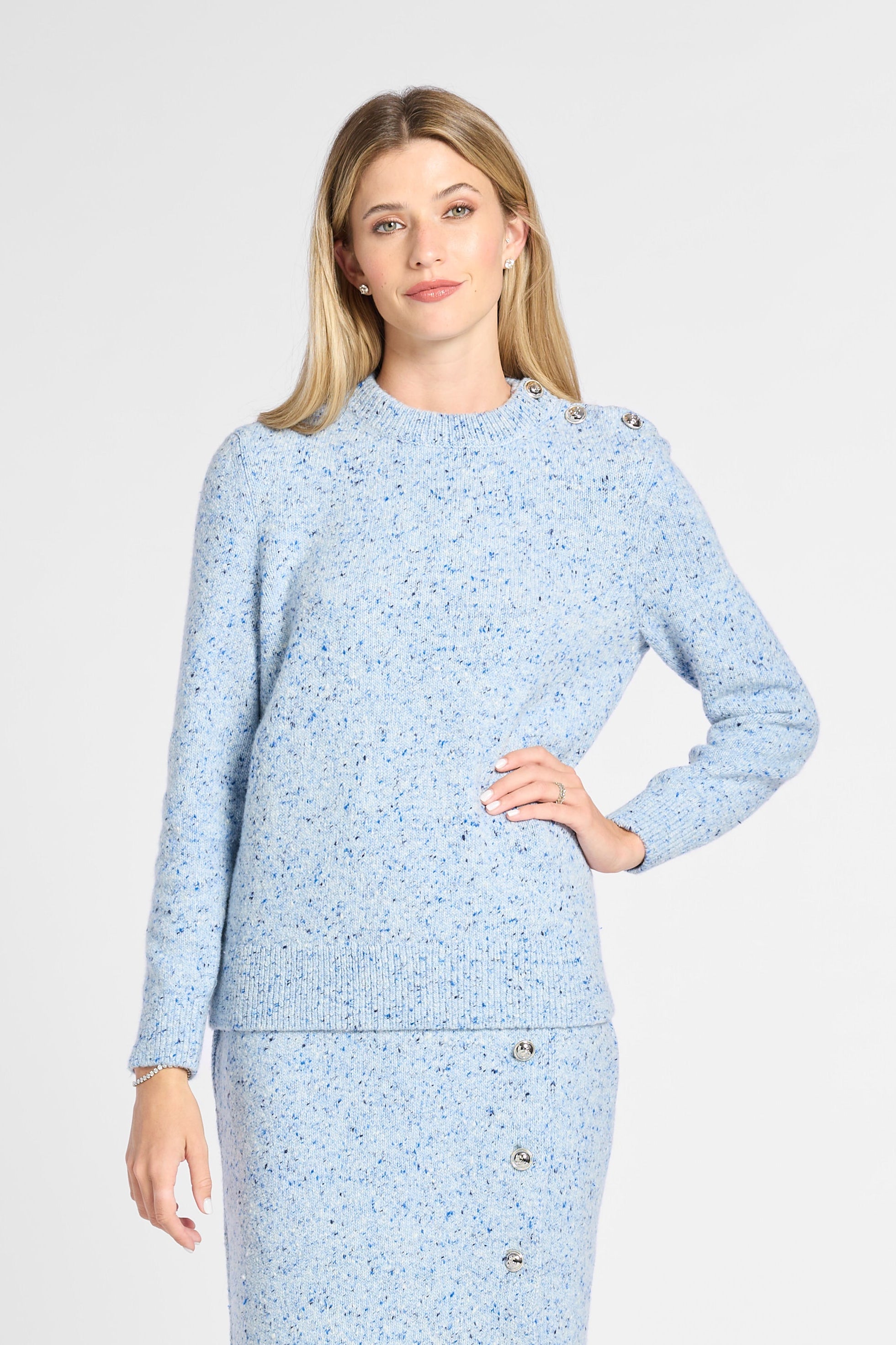 A woman modeling a light blue tweed long-sleeve midi dress with button details down the front and black knee-high boots, set against a plain light gray studio background.