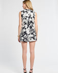 Woman modeling a pair of black and white floral shorts on a white background