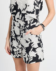 Woman modeling a pair of black and white floral shorts