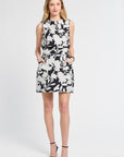 Woman wearing a sleeveless top and mini skirt a floral pattern on a white backdrop