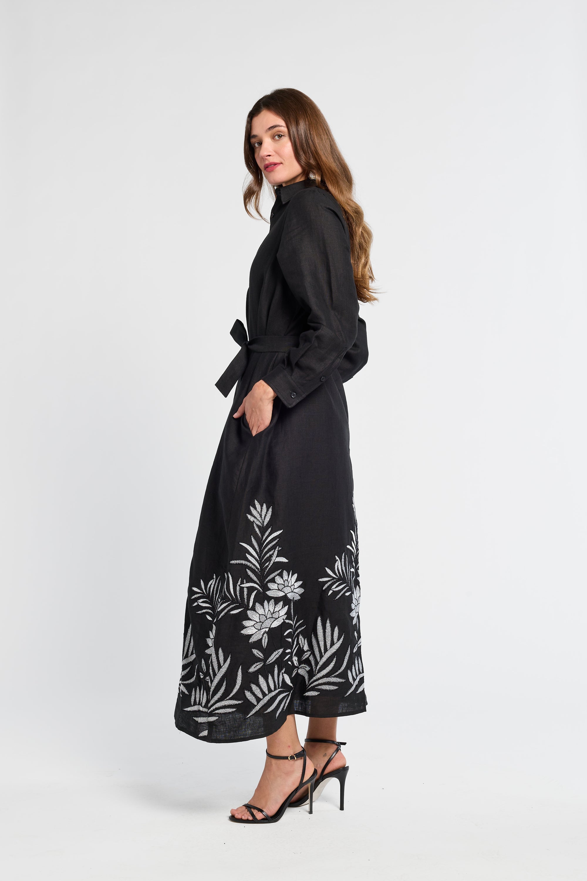 Woman wearing a black dress with white floral patterns on a white background