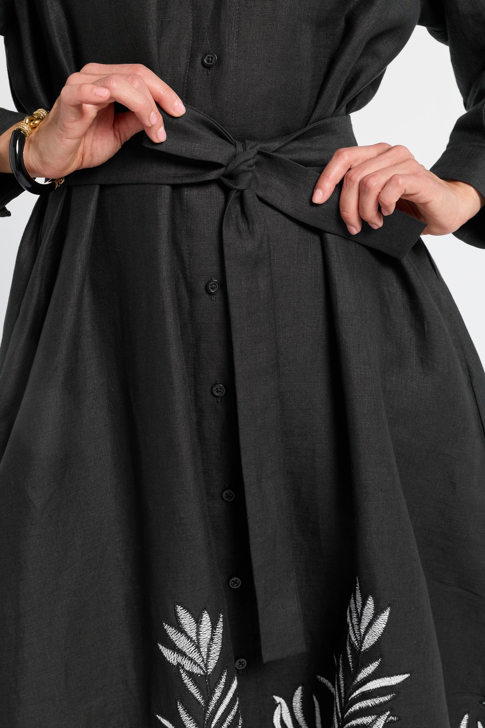 Black button down dress with floral patterns on a plain background