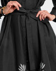 Black button down dress with floral patterns on a plain background