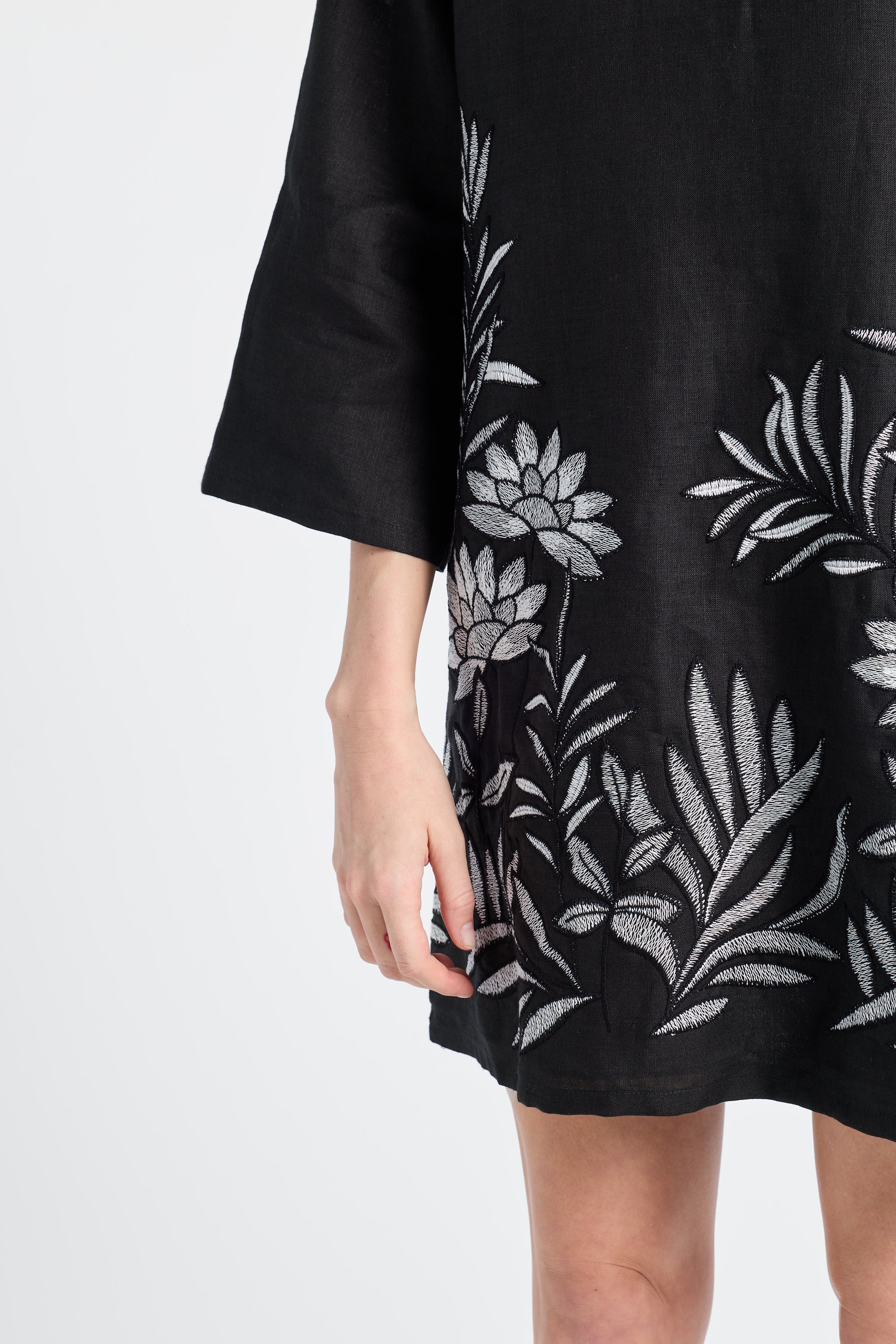 Black dress with floral embroidery on a white background