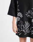 Black dress with floral embroidery on a white background