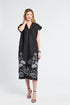 Woman wearing a black dress with white floral patterns on a white background