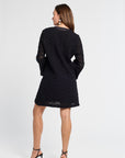 Woman wearing a black dress with lace details on a white background