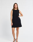 Woman wearing a black sleeveless dress on a white background