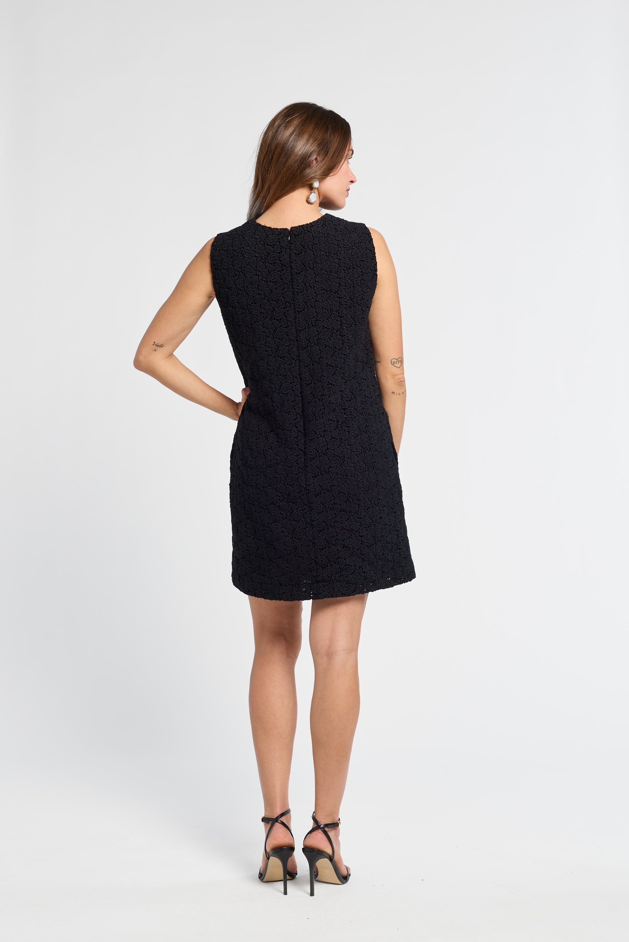 Woman wearing a black mini dress on a white background