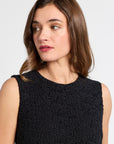 Woman wearing a black sleeveless dress against a white background