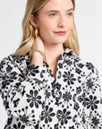 Woman modeling a black and white floral long sleeve blouse against a plain background