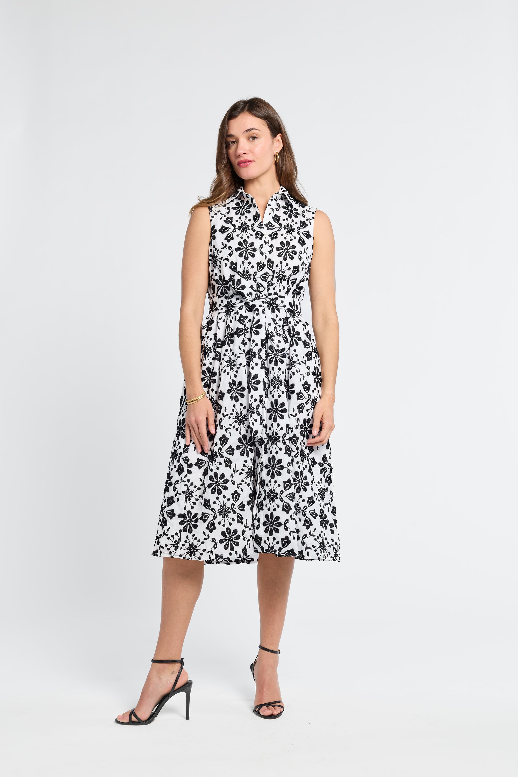 Woman wearing a black and white midi floral dress on a white background