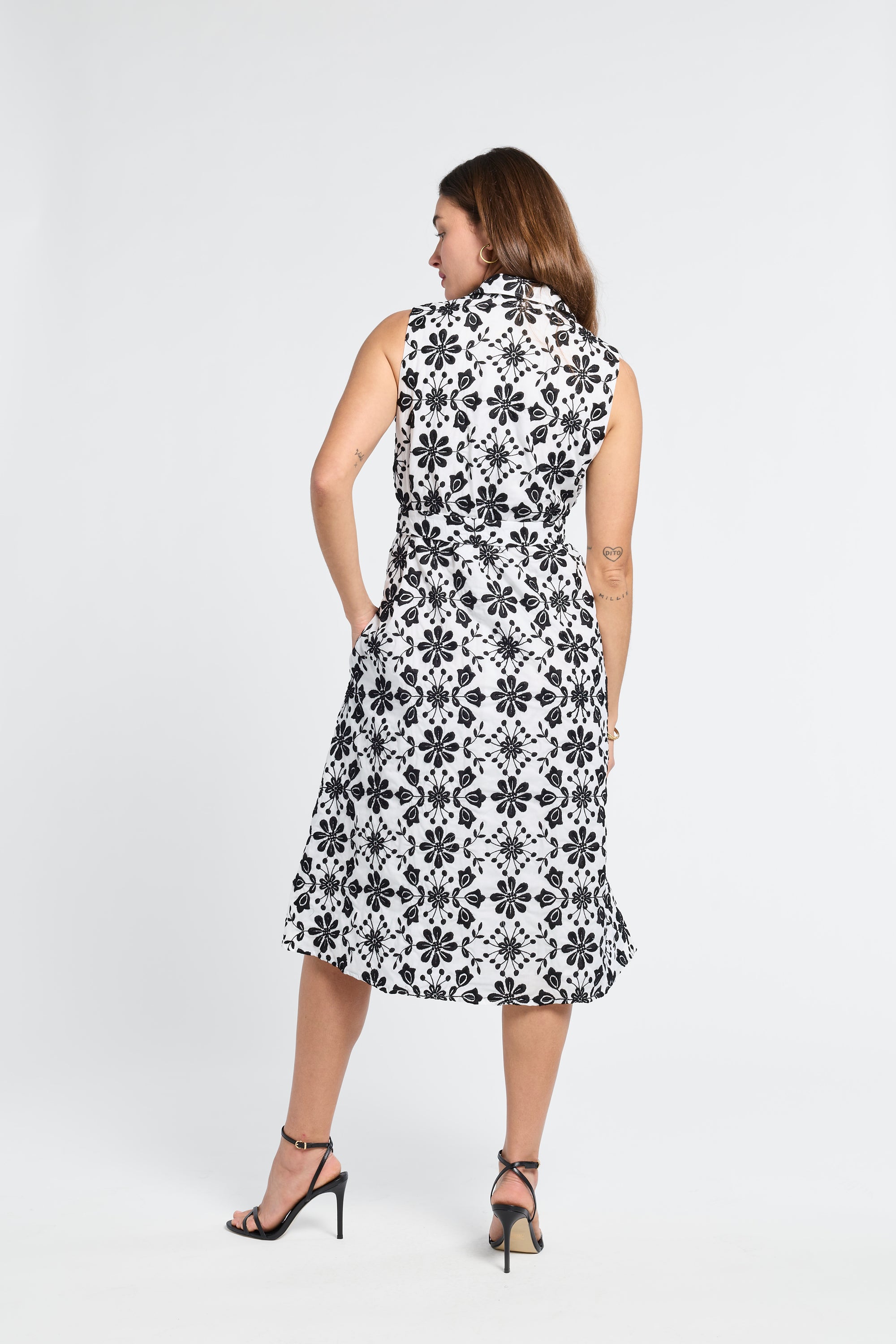 Woman dressed in a black and white floral dress on a white background
