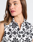 Woman modeling a sleeveless dress with black floral pattern on a white background