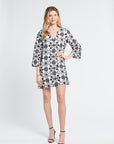 Woman wearing a black and white floral caftan dress on a white background