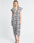 Woman wearing a black and white floral caftan on a white background