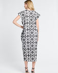 Woman wearing a black and white floral maxi dress on a light gray background