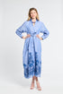 Woman wearing a blue maxi dress with floral embroidery on a white background