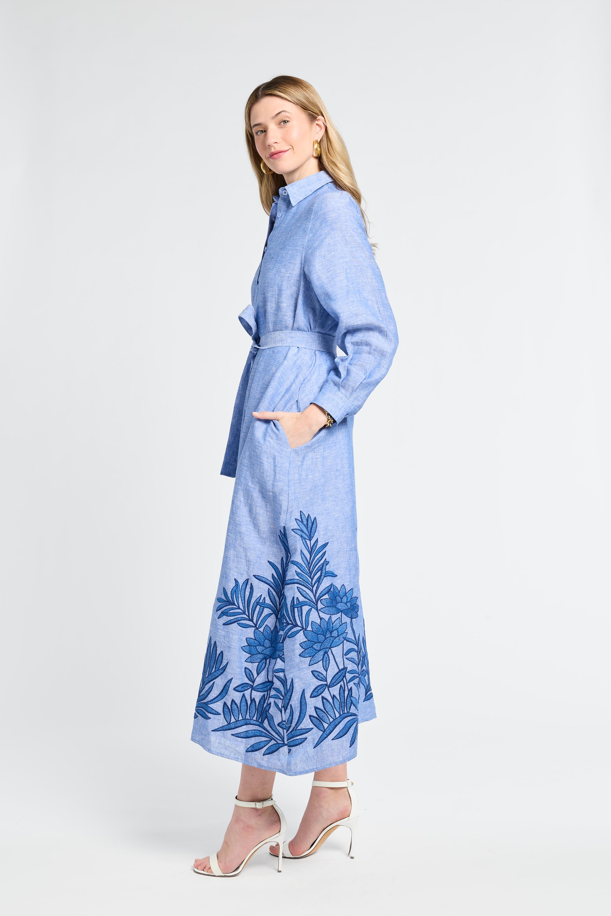 Woman wearing a blue floral dress with embroidery on a white background
