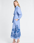 Woman wearing a blue floral dress with embroidery on a white background