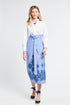 Woman wearing a white blouse and blue embroidered floral skirt on a white background